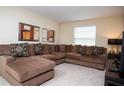 Inviting living room with plush sectional sofa, neutral carpeting, and modern decor at 2928 Buccaneer Palm Rd, Kissimmee, FL 34747