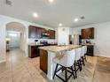 Spacious kitchen with stainless appliances, tile flooring, granite counters and seating at the island at 29746 Anahid Dr, Leesburg, FL 34748