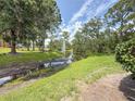 Scenic community view with a pond, fountain, mature trees, and green spaces at 3034 Parkway Blvd # 102, Kissimmee, FL 34747