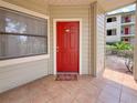 Close up of red front door and welcome mat, inviting entrance to the residence at 3034 Parkway Blvd # 102, Kissimmee, FL 34747
