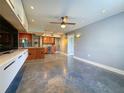 Open-concept living room featuring modern lighting, polished concrete floors, and an adjacent kitchen at 3034 Parkway Blvd # 102, Kissimmee, FL 34747