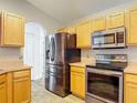 Modern kitchen featuring stainless steel appliances and wood-toned cabinets for a warm and inviting feel at 3130 Clewiston St, Deltona, FL 32738