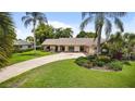 Charming single-story home boasts a stone accent facade, lush landscaping, and an extra-long driveway at 316 Cambridge Dr, Longwood, FL 32779