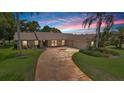 Charming single-story home boasts a stone accent facade, lush landscaping, and an extra-long driveway at 316 Cambridge Dr, Longwood, FL 32779