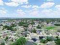 Aerial view of neighborhood featuring lush green trees and a variety of single-Gathering homes with vibrant blue skies at 331 Erie Ct, Kissimmee, FL 34759