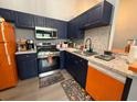 Bright kitchen featuring stainless steel appliances, navy cabinets, and marble countertops at 3391 S Kirkman Rd # 1236, Orlando, FL 32811