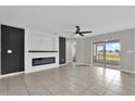 Bright living room with a modern fireplace, tile flooring and sliding glass doors to the patio at 3405 Yarian Dr, Haines City, FL 33844