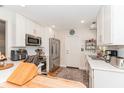 Bright kitchen with white cabinets, stainless steel appliances, and hardwood floors at 3460 Fairway Ln, Orlando, FL 32804