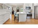 Bright kitchen with white cabinets, stainless steel appliances, and a large island with bar seating at 3460 Fairway Ln, Orlando, FL 32804