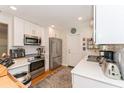 Updated kitchen featuring white cabinets, stainless steel appliances, and ample counter space at 3460 Fairway Ln, Orlando, FL 32804