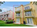 Rear exterior view showcasing the townhome's three stories, patio, and well-maintained lawn at 4816 Tidecrest Ave # 178, Orlando, FL 32819