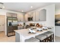 Modern kitchen with stainless steel appliances, gray cabinets, and a breakfast bar with seating at 483 Wayland Dr, Haines City, FL 33844