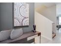 Stylish entryway with modern console table, artwork, and staircase access at 4834 Lullaby Ln, Kissimmee, FL 34746