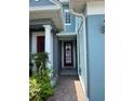 Inviting covered entryway with a red door and sidelights, offering a warm welcome to the home at 6024 Chapledale Dr, Orlando, FL 32829