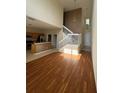 Open-concept living room with wood floors, staircase, and access to the kitchen at 6024 Chapledale Dr, Orlando, FL 32829