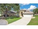 Attractive single-story home with a long driveway, garage, and mature trees at 608 Ashwell Ct, Debary, FL 32713