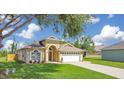 Charming single-story home with well-kept lawn, arched doorway, and convenient garage at 608 Ashwell Ct, Debary, FL 32713