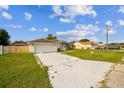 View of white single-story home with a long driveway and lawn at 657 Mckinley Ct, Kissimmee, FL 34758