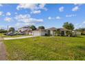 A white single-story home featuring an attached garage and front yard at 657 Mckinley Ct, Kissimmee, FL 34758