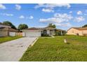 View of white single-story home featuring an attached garage at 657 Mckinley Ct, Kissimmee, FL 34758