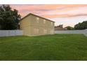 Expansive backyard features lush green grass, and a white privacy fence at 670 Bluebill Ct, Poinciana, FL 34759