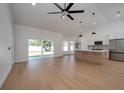 Bright living room with wood floors, a ceiling fan, and kitchen featuring an island with marble countertops at 7646 Coconut Creek Ct, Orlando, FL 32822