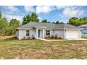 Cozy one-story home with a gray roof, easy-to-maintain landscaping, and an attached two-car garage at 8 Water Trce, Ocala, FL 34472