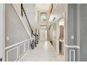 Inviting foyer features soaring ceilings, staircase, and half bathroom with stylish pedestal sink at 811 Sherbourne Cir, Lake Mary, FL 32746