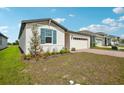 Lawn view of a single-story home featuring an attached two-car garage and manicured lawn at 1100 Griffon Ave, Lake Alfred, FL 33850