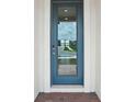 Stylish front door with glass panel, offering a glimpse of the exterior and security features at 1100 Griffon Ave, Lake Alfred, FL 33850