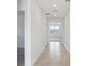 Bright hallway with tile floors, recessed lighting and doors that lead to other rooms at 1100 Griffon Ave, Lake Alfred, FL 33850