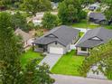Aerial view showcasing a well-manicured lawn, and an attractive single-story home with grey driveway at 1113 Naples Dr, Orlando, FL 32804