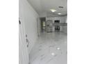 Bright, updated kitchen featuring stainless steel appliances, white cabinets, and elegant marble-look flooring at 1241 Cleveland Ave, Apopka, FL 32703