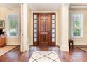 Elegant foyer with hardwood floors, a decorative rug, and a wood front door with sidelights at 1355 Hibiscus Ave, Winter Park, FL 32789