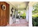 Inviting front porch with rocking chairs and a wood door with sidelights at 1355 Hibiscus Ave, Winter Park, FL 32789