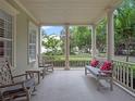 Relaxing front porch featuring rocking chairs, a bench with pillows, and classic columns at 1438 Stickley Ave, Celebration, FL 34747