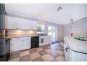 Well-lit kitchen with white cabinetry, stainless steel sink, and outside access at 146 Hidden Pointe Ln, Groveland, FL 34736