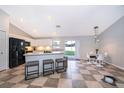 Bright kitchen with white cabinets, black appliances, and breakfast bar seating at 146 Hidden Pointe Ln, Groveland, FL 34736