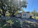 Charming bungalow-style home featuring a partially fenced yard and mature trees under a clear sky at 1500 43Rd St, Orlando, FL 32839