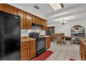 Kitchen with wooden cabinets, black appliances, tile flooring, open to the dining area at 1588 Alloway Dr, Deltona, FL 32738