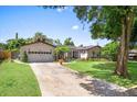 Inviting single-story home featuring a lovely front lawn, mature trees, and an expansive driveway at 2020 Geronimo Trl, Maitland, FL 32751