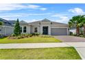 Beautiful single-story home boasts a lush lawn, landscaped beds, and a two-car garage with brick-paved driveway at 2171 Timber Creek Ln, Clermont, FL 34715