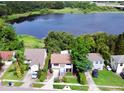Aerial view of a beautiful two-story home nestled near a tranquil lake, surrounded by lush greenery at 238 Lake Dr, Orlando, FL 32835