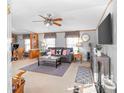 Cozy living room featuring a ceiling fan, grey sofa, and a view to dining area at 238 Lake Dr, Orlando, FL 32835