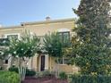 Inviting townhome with balcony framed by lush trees and landscaping, creating a serene and appealing exterior view at 2520 Bella Vista Dr, Davenport, FL 33897