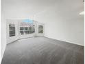 Spacious, carpeted living room with large windows and natural light at 3142 Britannia Blvd # C, Kissimmee, FL 34747