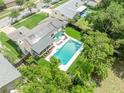 Overhead view of a backyard pool and patio with manicured lawn, solar panels, and a screened-in porch at 320 Bridle Path, Casselberry, FL 32707