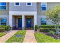 Welcome to this townhome's cheerful entryway with decorative accents and landscaping at 322 Annabelle Way, Davenport, FL 33837
