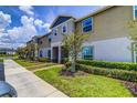 Inviting townhouse with well-maintained landscaping, lush lawn, and a sidewalk at 322 Annabelle Way, Davenport, FL 33837