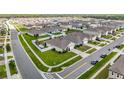 An aerial view of a quiet neighborhood with well-maintained homes, grassy lawns, and tree-lined streets under a sunny sky at 3980 Gadwall Pl, Leesburg, FL 34748